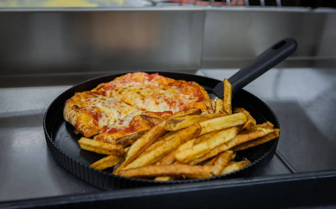 A personal pizza served with fries